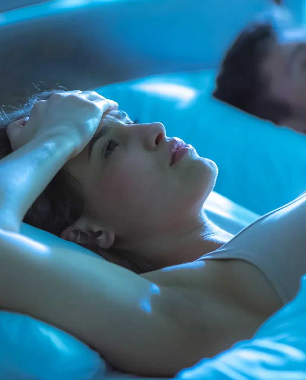 Giovane donna a letto che non riesce a dormire